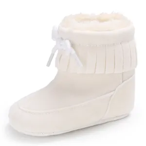 Close-up detail of white infant winter snow boots with soft fleece lining and fringe