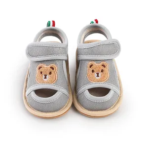 Nahaufnahme grauer Baby-Sandalen aus Mesh mit Bärenstickerei und weicher, rutschfester Sohle