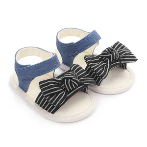 Detail von Baby-Lauflernsandalen mit gestreiften Schleifen und blauen Denim-Riemen