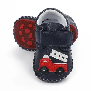 Chaussure premier pas marine motif camion de pompier et semelle antidérapante rouge.