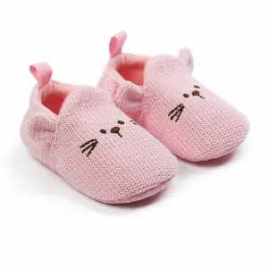 Detailed view of pink knitted baby shoes with soft soles and cartoon cat face design