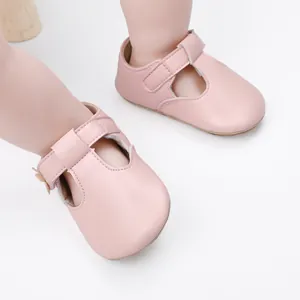 Macro view of pink soft sole baby girl princess shoes featuring a secure T-strap closure