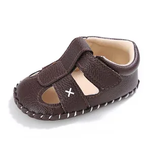Detailansicht der braunen Baby-Lauflernsandalen aus Kunstleder mit Kreuzmotiv