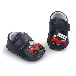 Vue détaillée des chaussures bébé bleu marine avec motif camion pompier et couture main