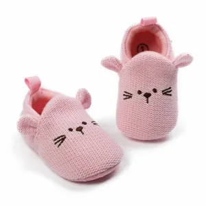 Detailed macro view of cute pink knitted baby shoes with cartoon mouse face and soft soles