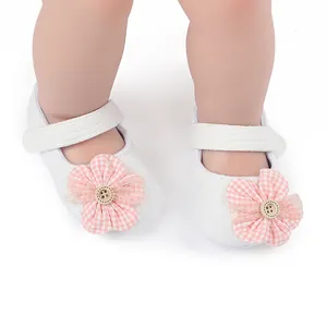 Primer plano detallado de zapatos para bebé niña con decoración de flores de cuadros rosa