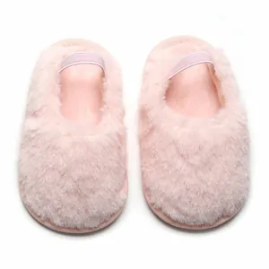 Vista dettagliata di babbucce in peluche rosa per neonati con cinturino elastico.