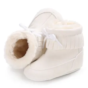 Detailed view of white baby snow boots with cozy fleece lining and decorative tassel fringe