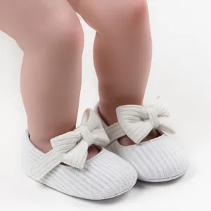 Detailed view of white knitted toddler princess shoes with a soft oversized bow
