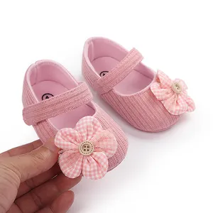 Vista detallada de zapatos rosa para bebé niña con delicada decoración de flores de tela