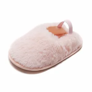 Vista ravvicinata delle pantofole neonato in peluche rosa con trama soffice e cinturino elastico