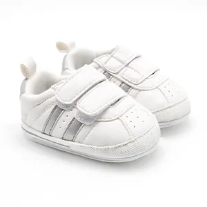 Detailed side view of white baby walking sneakers with double hook and loop straps.