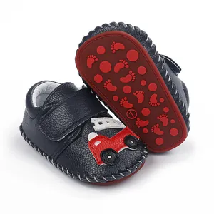 Vue détaillée de chaussures bébé bleu marine avec appliqué voiture rouge et semelle antidérapante