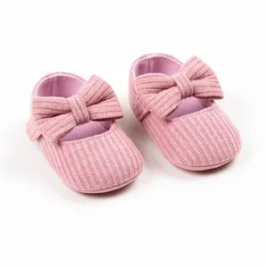 Detailed view of soft pink ribbed knit baby girl princess walker shoes with large bow