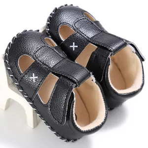 Detailansicht der schwarzen Baby-Lauflern-Sandalen mit weißen Kreuzstich-Verzierungen