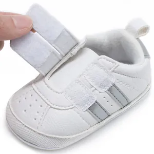 Detail view of adjustable double Velcro straps on white baby walker shoes for infants