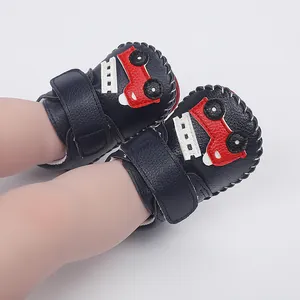 Vue détaillée de chaussures de marche pour bébé cousues main avec un motif de voiture