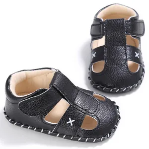 Detaillierte Makroansicht schwarzer Baby-Lauflern-Sandalen aus Kunstleder mit weißen Stichen