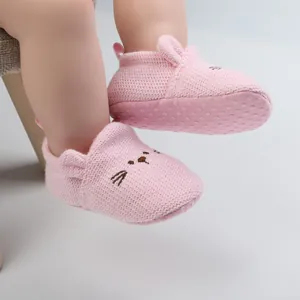 Detail of pink knitted baby walking shoes with cartoon cat face and anti-slip sole