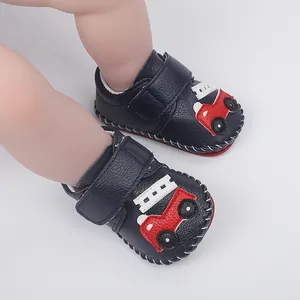 Gros plan de chaussures de marche pour bébé bleu marine avec motif de voiture rouge