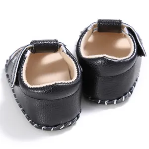 Nahaufnahme der schwarzen Baby-Lauflern-Sandalen mit strukturiertem Leder und weißen Nähten
