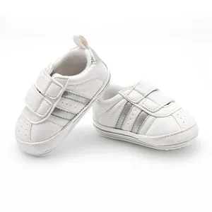 Soft white baby walking shoes with anti-slip rubber soles and decorative silver side stripes