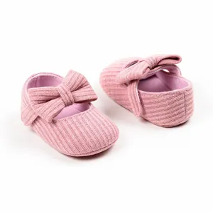 Detailed view of pink knitted baby princess shoes with a soft bow and ribbed texture