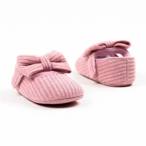 Close-up detail of soft pink ribbed knit baby princess shoes featuring a cute decorative bow