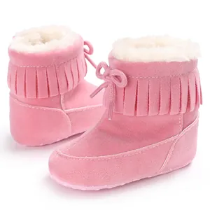 Soft pink baby snow boots with fringe detail and plush faux fur lining for winter