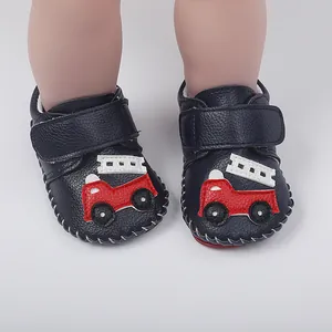 Gros plan de chaussures de marche pour bébé bleu marine avec écusson de camion de pompier