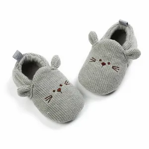 Macro view of gray knit baby shoes featuring cute embroidered cat face and 3D ears
