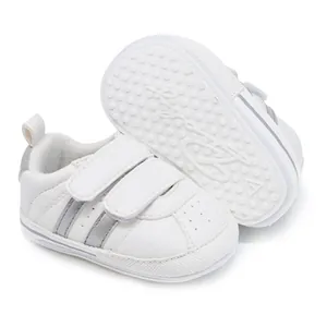 Detailed view of white baby walker shoes with silver stripes and anti-slip sole