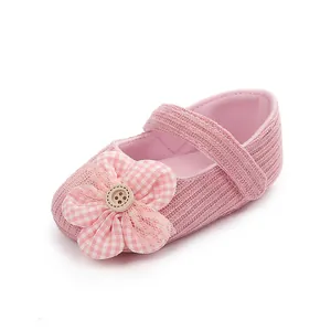 Primer plano de zapato rosa de bebé niña con un adorno floral y textura de punto