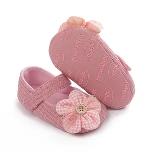 Primer plano detallado de zapatos de bebé rosa con flor de cuadros y botón de madera decorativo