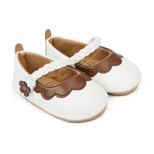 Detailaufnahme von weißen und braunen Babylauflernschuhen mit geflochtenem Riemen