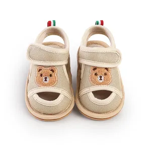 Detail der atmungsaktiven beige Mesh-Babysandalen mit niedlichem Bären-Stickerei