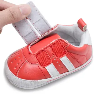 Detail view of red baby walking shoe showing the adjustable Velcro strap closure