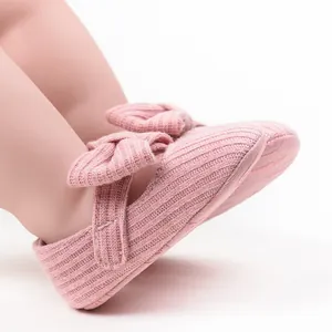 Detailed close-up view of pink knitted baby pre-walker shoes featuring a large cute bow