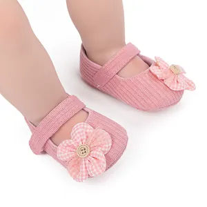 Detail of pink ribbed baby walking shoes with soft soles and decorative plaid flowers