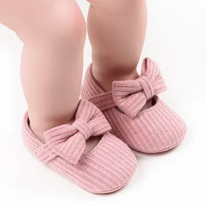 Detailed view of pink knitted baby girl Mary Jane shoes featuring a soft bow ornament
