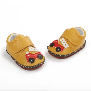 Détail de chaussures de marche jaunes pour bébé avec motif voiture de dessin animé