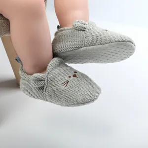 Close-up of knitted baby walker shoes with cute embroidered cat face and non-slip sole