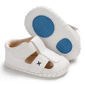 Detail der weißen Baby-Lauflernsandalen mit blauer rutschfester Sohle und Klettverschluss.