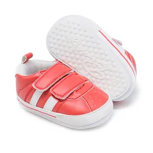 Detailed view of red and white baby walking shoes featuring non-slip dotted rubber soles