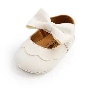 Close-up detail of soft PU leather baby princess shoes with a large cream bow