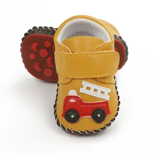 Gros plan de chaussures de marche bébé jaunes avec motif pompier et semelle antidérapante
