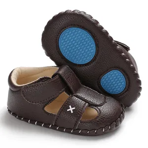 Detailaufnahme brauner Baby-Ledersandalen mit rutschfesten blauen Gummisohlen