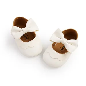 Detail view of off-white baby princess shoes with large leather bows