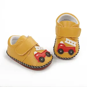 Détail de chaussures jaunes pour bébé avec camion de pompier et semelle en caoutchouc rouge
