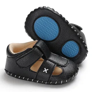 Detailansicht der schwarzen Baby-Lauflernsandale mit rutschfester blauer Gummisohle.